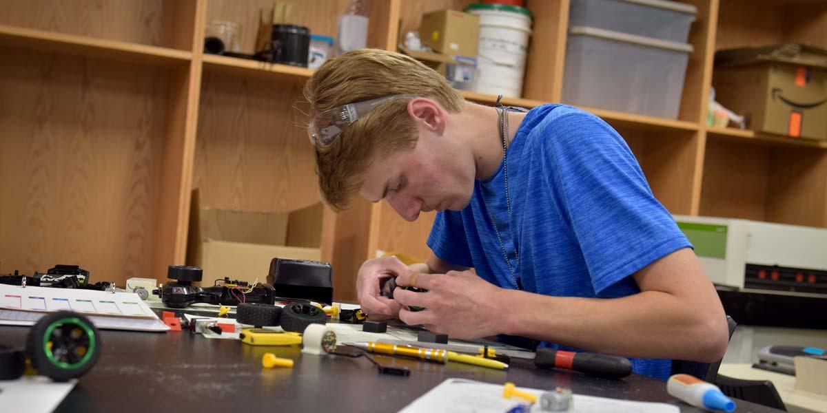 A BCYC Immersion student assembles an engineering project in class